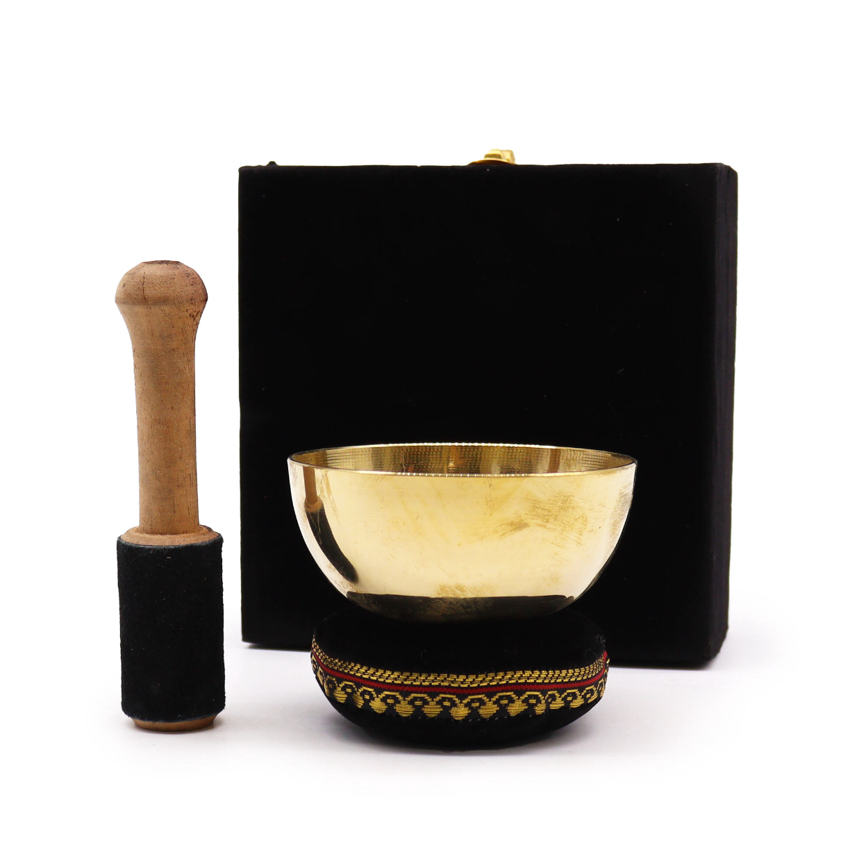 Brass singing bowl with wooden striker and black carrying case on a white background