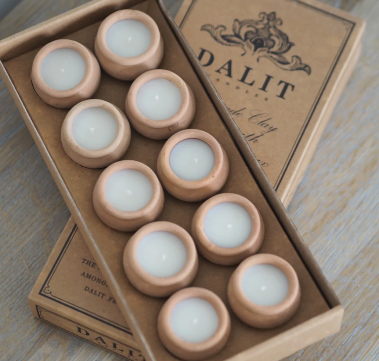 Set of clay candles in a box with 'DALIT' branding on a wooden surface