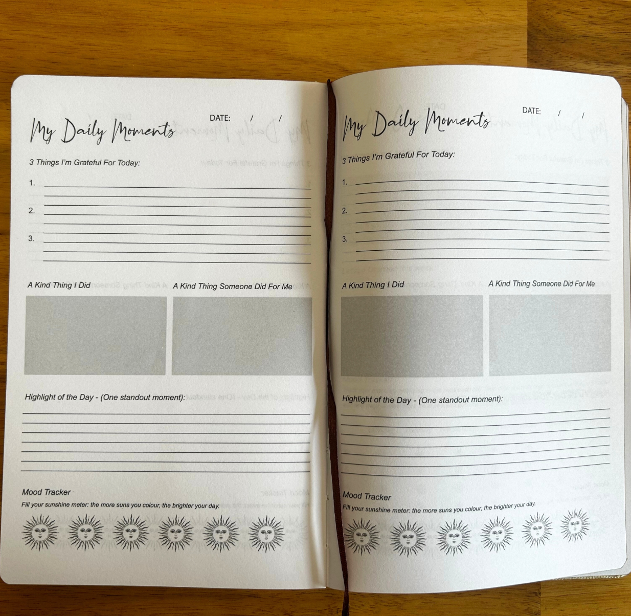 Open notebook with daily reflection pages on a wooden surface