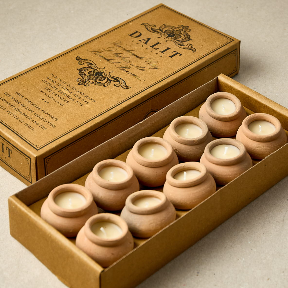 Set of clay pots with candles in a brown box labeled 'DALIT'.