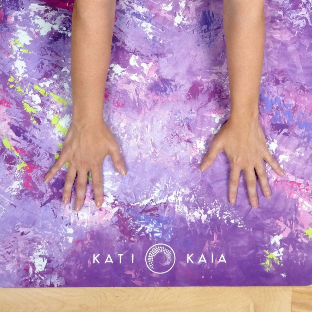Kati Kaia artistic yoga mat in purple shades with abstract design and hands pressing down
