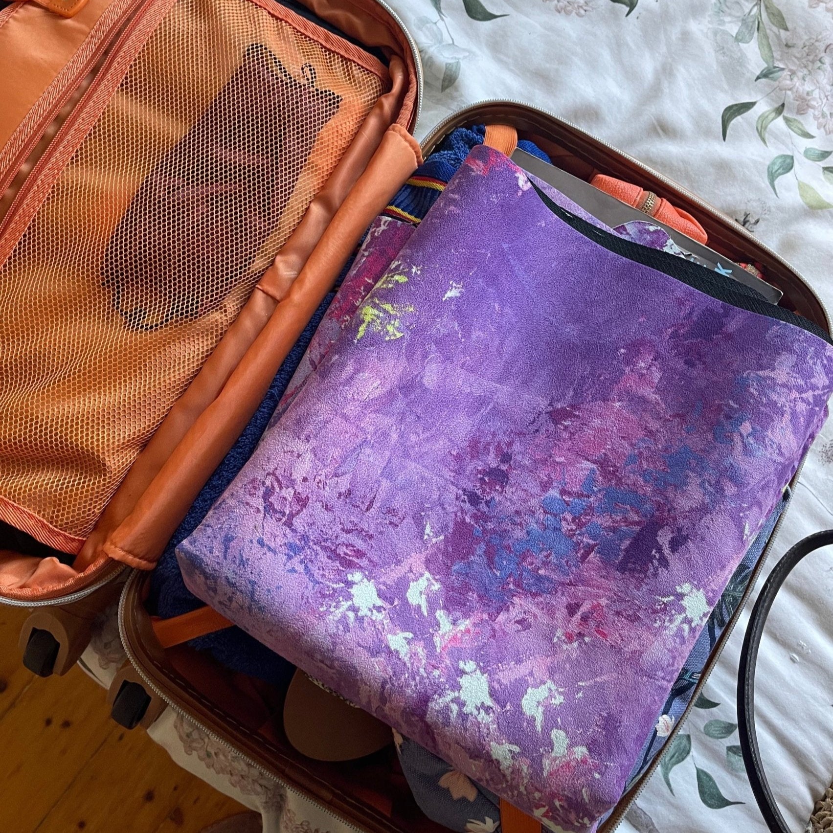 Folded Circe Purple Travel Mat by Kati Kaia packed inside a suitcase ready for travel