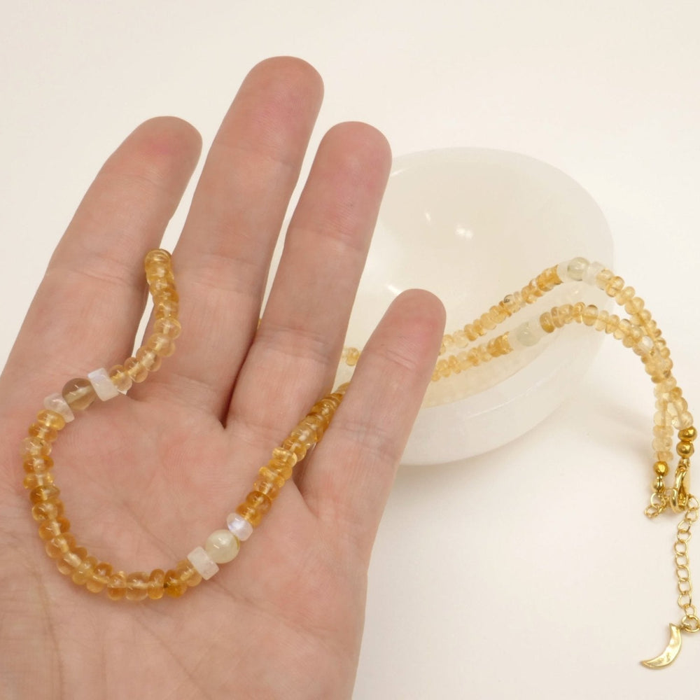 Kati Kaia citrine crystal set for meditation displayed on a hand with a white bowl background