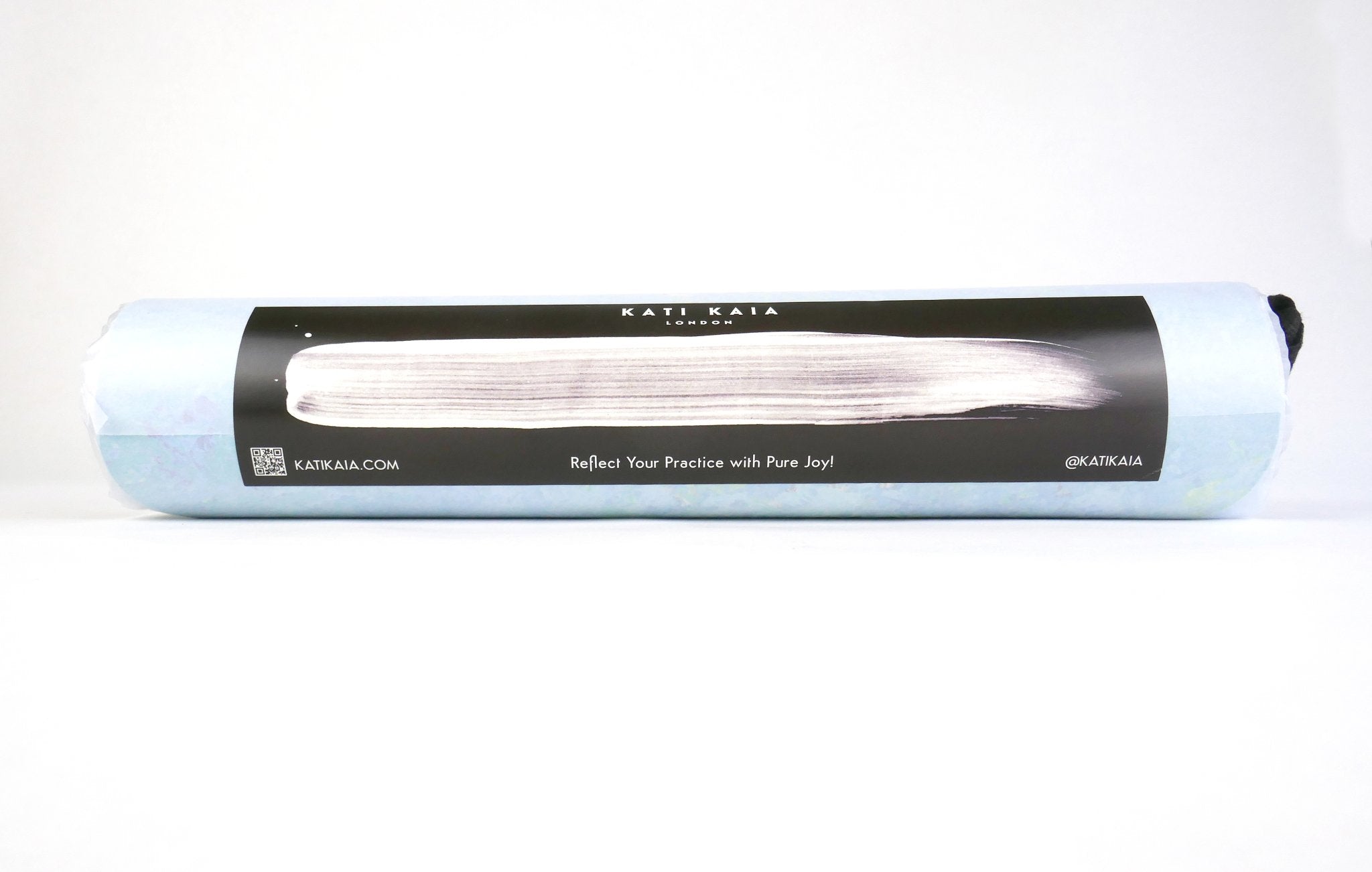 Kati Kaia Thalassa yoga pad for travel rolled in a light blue carrying bag with black strap