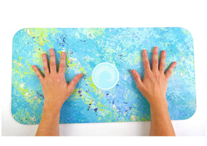 Thalassa yoga pad for travel with ocean-inspired blue and green design showing hands on mat